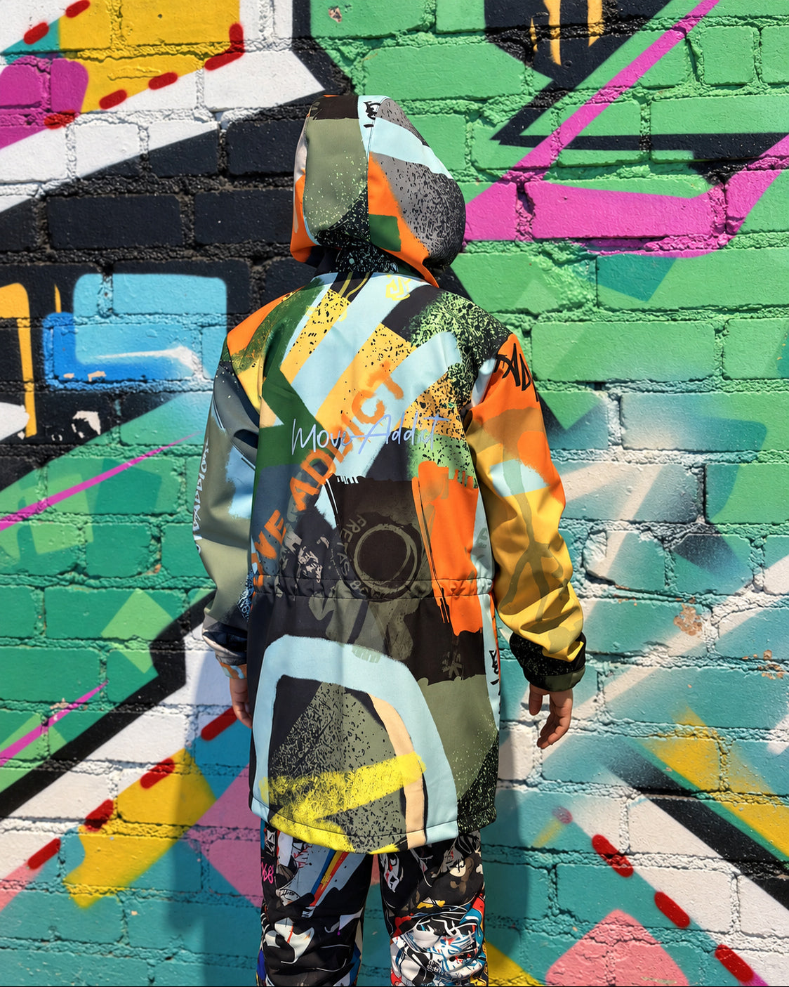 Child wearing MoveAddict Green Graffiti print kids' winter parka - back view