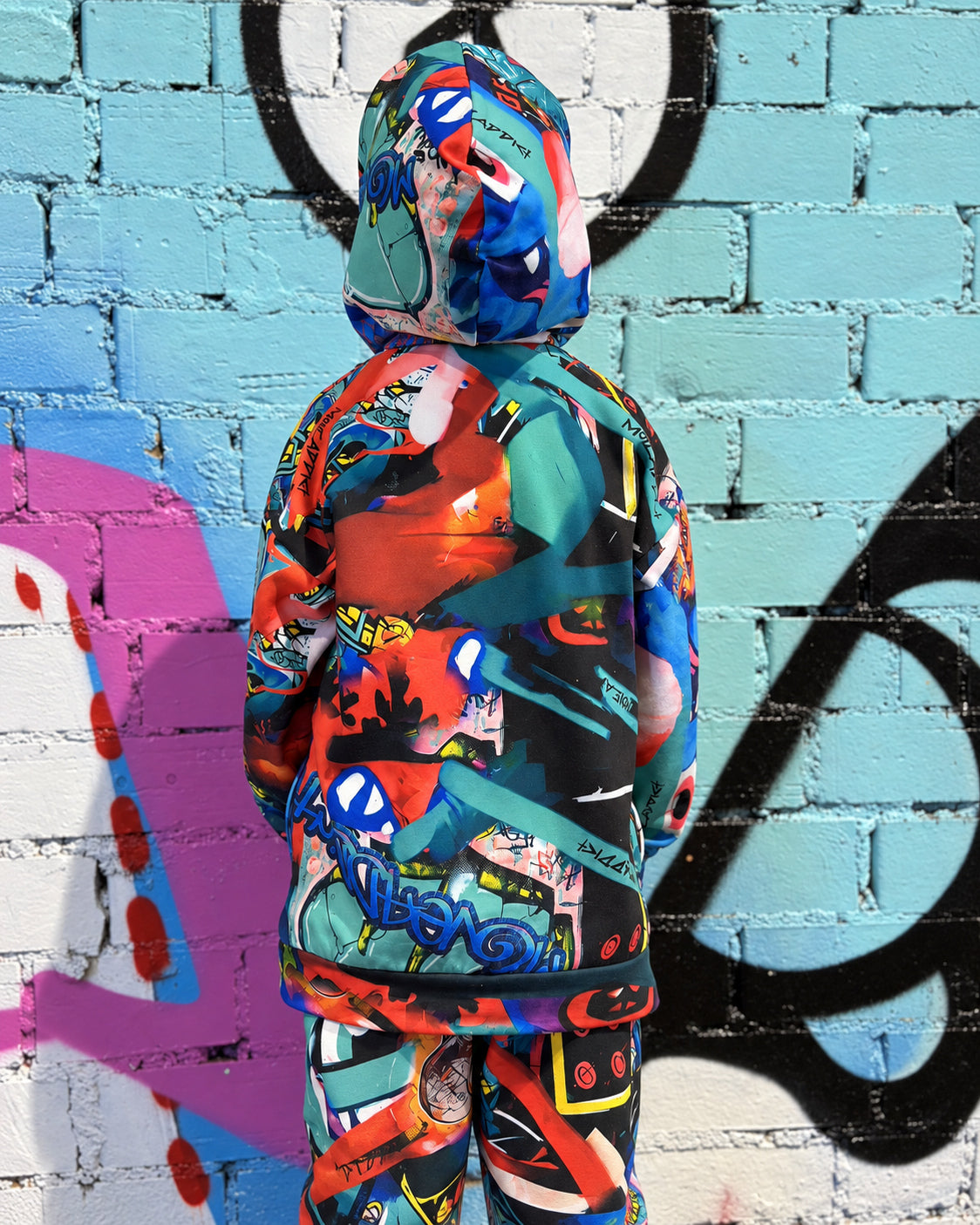Child wearing MoveAddict Monster Party print kids' oversized hoodie - hood detail, side view