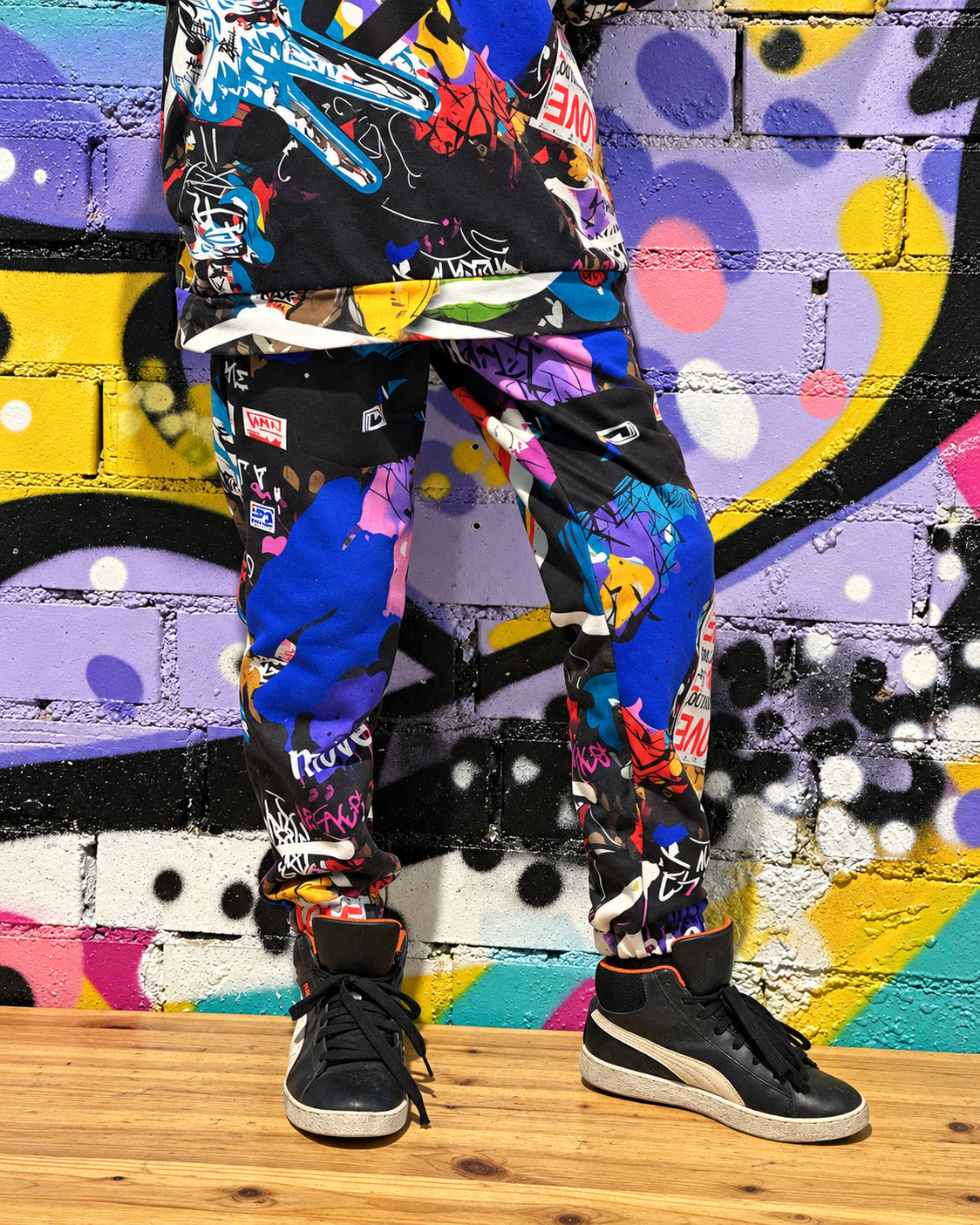 Child wearing MoveAddict Love and Peace print kids' joggers - close-up of the pants