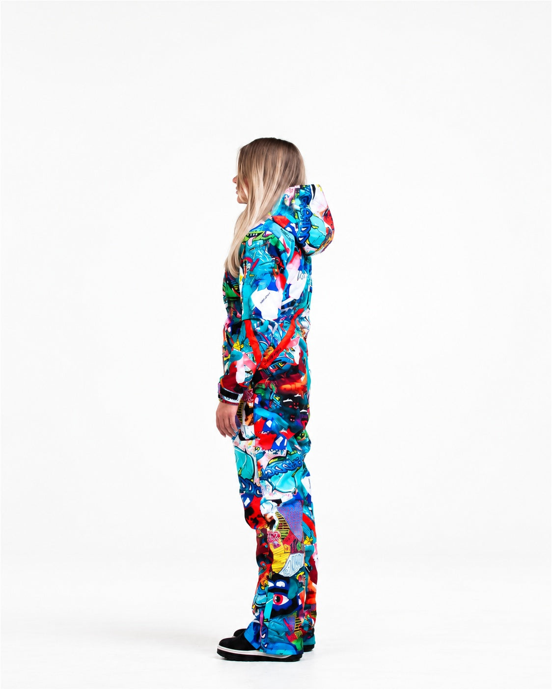 Woman wearing MoveAddict Monster Party print one-piece snowboard and ski suit – side view