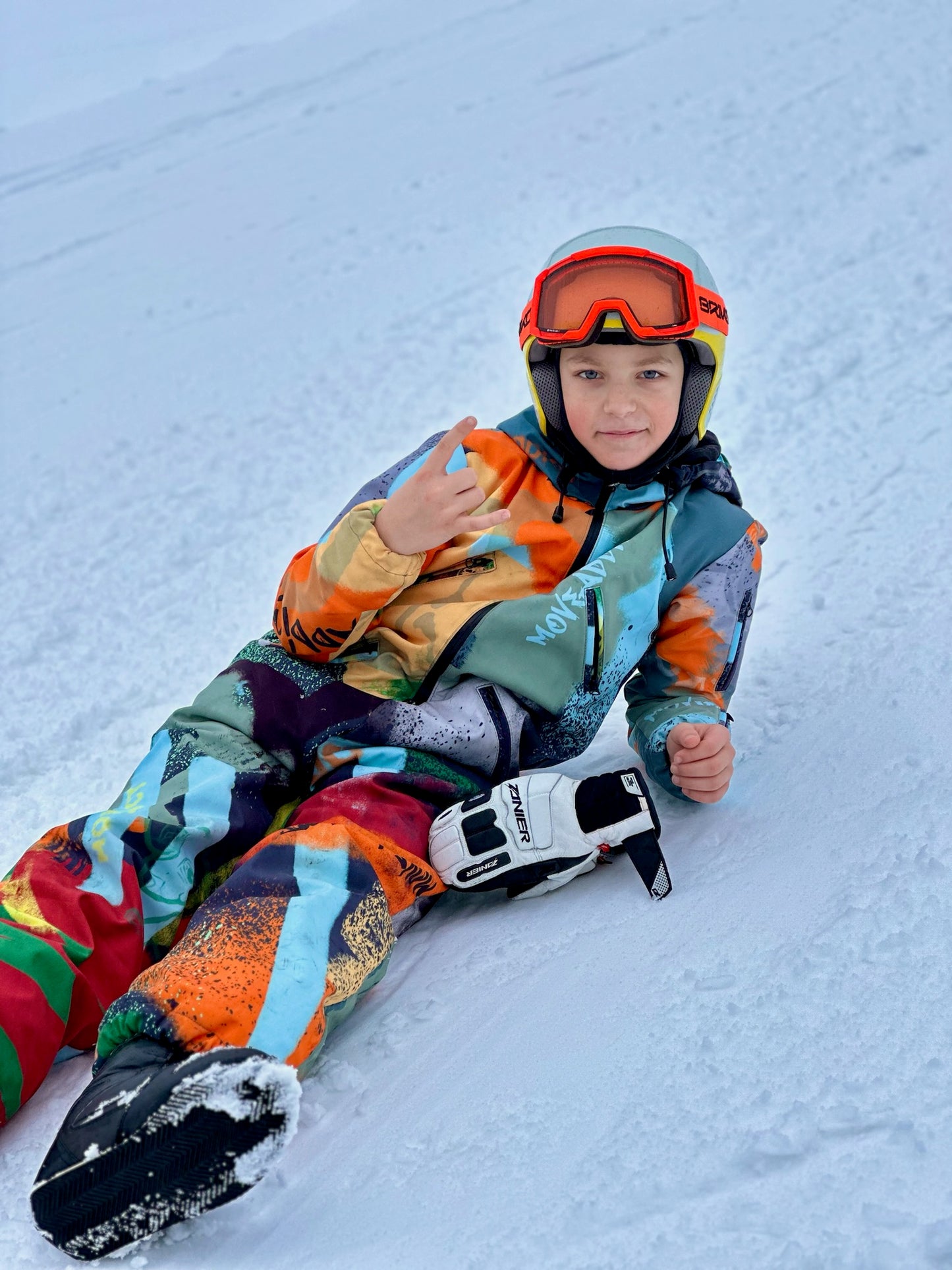 Bērnu ziemas kombinezona noma. Zaļi oranža apdruka. Piemērots augumam 152 cm.