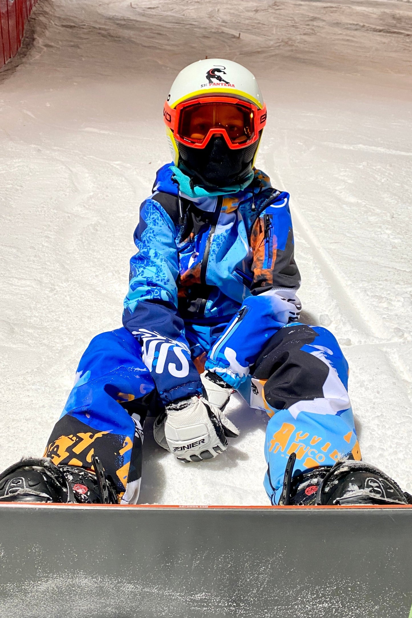 Bērnu ziemas kombinezona noma. Zili oranža apdruka. Piemērots augumam 164 cm