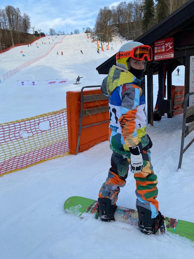 Bērnu ziemas kombinezona noma. Zaļi oranža apdruka. Piemērots augumam 152 cm.