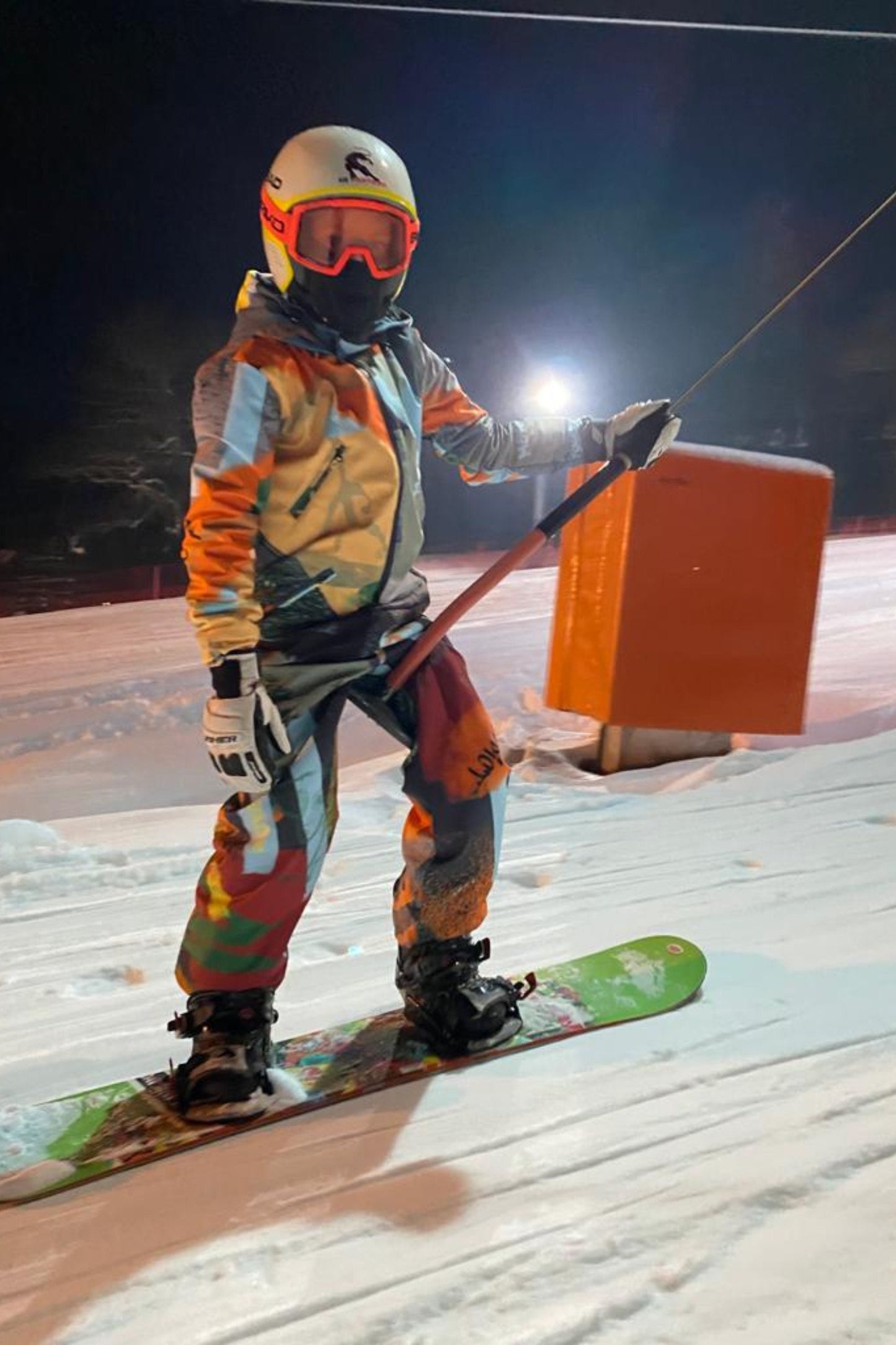 Bērnu ziemas kombinezona noma. Zaļi oranža apdruka. Piemērots augumam 152 cm.